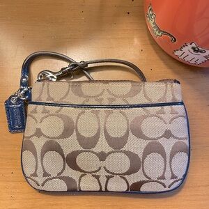 Coach signature C wristlet with navy blue trim and coach mini tag. EUC.